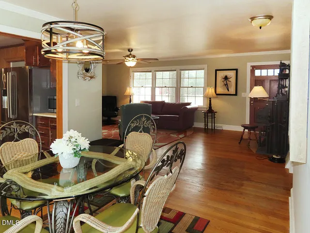 a dining room with furniture a chandelier and wooden floor