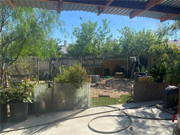a backyard of a house with fountain table and chairs potted plants
