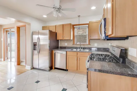 a kitchen with stainless steel appliances granite countertop a stove a sink and a refrigerator