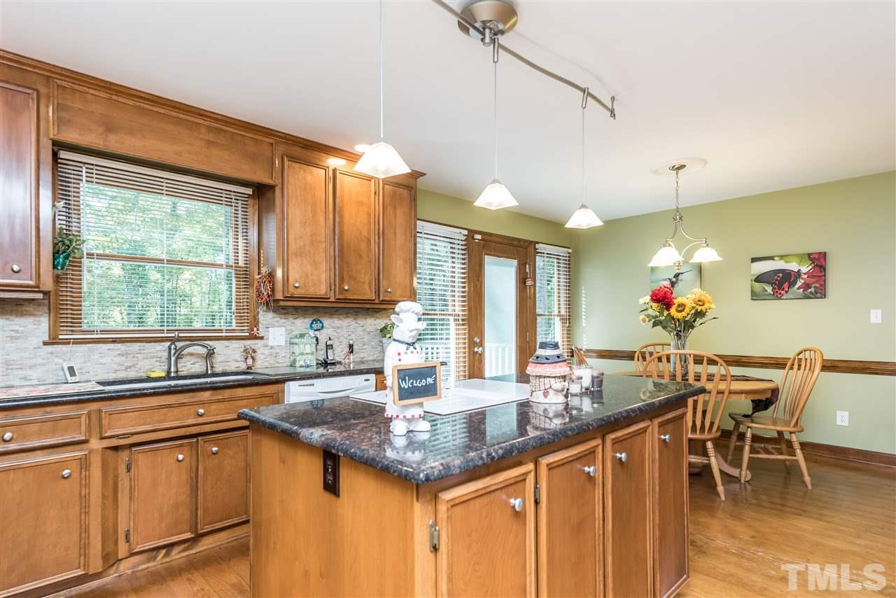 3104 Hickory Road Raleigh, NC 27616 - Photo 7 of 25 a kitchen with granite countertop a sink dining table chairs and chandelier