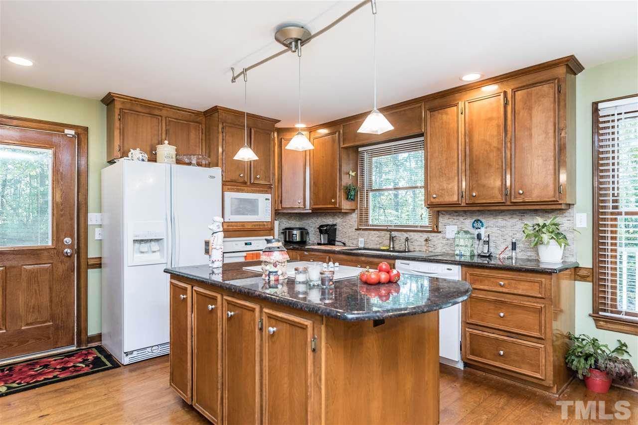 3104 Hickory Road Raleigh, NC 27616 - Photo 9 of 25 a kitchen with a refrigerator a sink dishwasher stove and oven with wooden cabinets