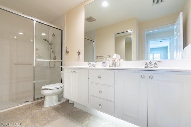 7630 Novara Court Naples, FL 34114 - Photo 26 of 33 a bathroom with a double vanity sink toilet and shower