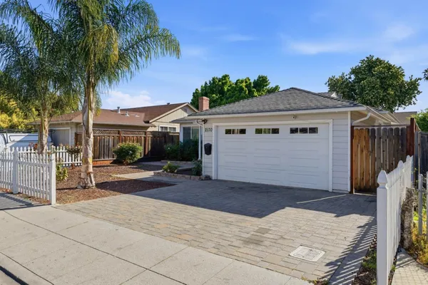 a view of a house with a yard and potted plants