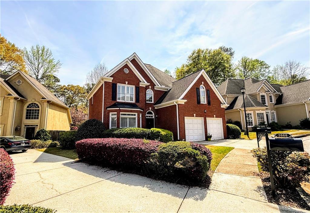 a view of residential houses with cars parked in front of it