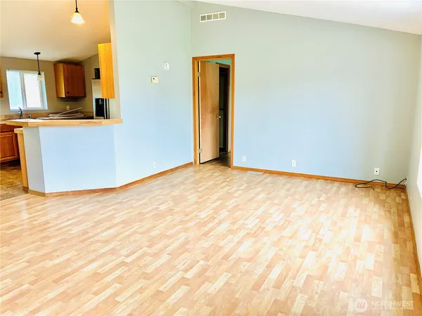 a view of a room with wooden floor and a window