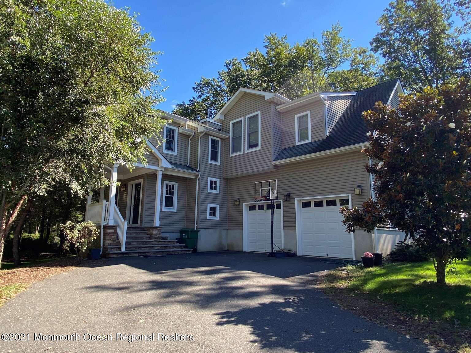 341 Oak Glen Road Howell, NJ 07731 - Photo 1 of 19 a front view of a house with a yard and garage