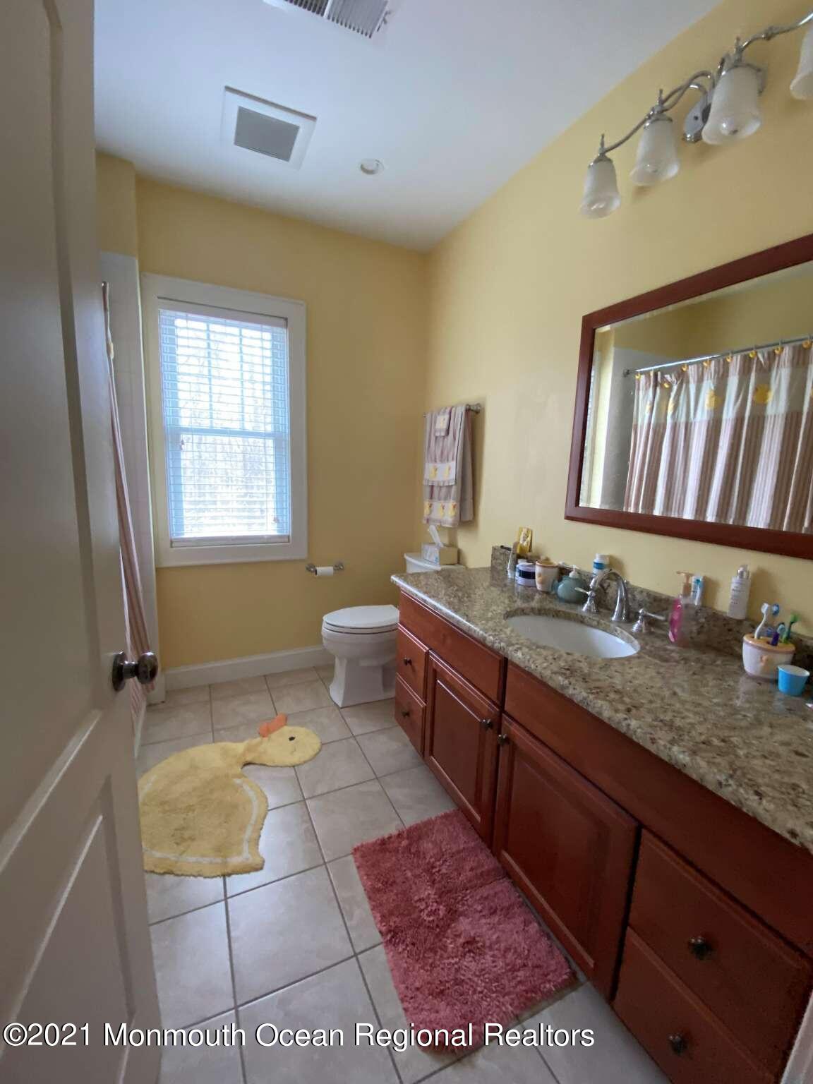 341 Oak Glen Road Howell, NJ 07731 - Photo 17 of 19 a bathroom with a granite countertop sink a mirror and a bathtub