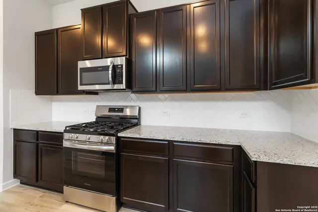 a kitchen with granite countertop stainless steel appliances and cabinets