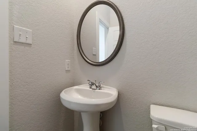 a bathroom with a sink a toilet and a mirror