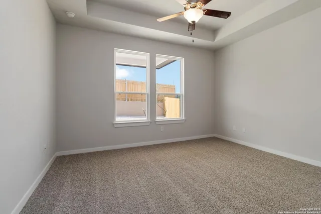 an empty room with a window and a fan