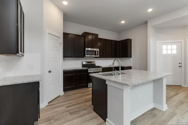 a kitchen with stainless steel appliances granite countertop a stove top oven a sink and dishwasher