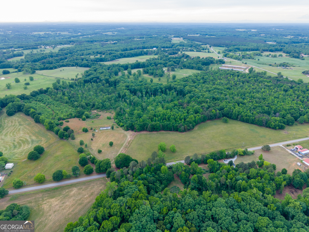 747 Sam Swindle Road Commerce, GA 30530 - Photo 3 of 12 an aerial view of green landscape with trees houses and mountain view