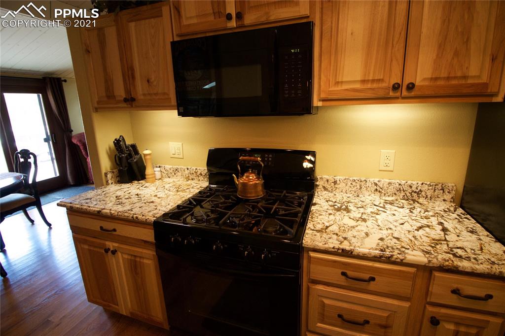 2160 Old North Gate Road Colorado Springs, CO 80921 - Photo 13 of 34 a kitchen with stainless steel appliances granite countertop a stove a sink and a microwave