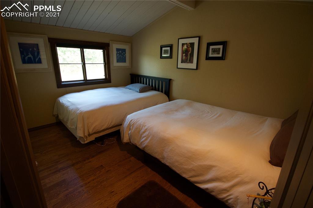 2160 Old North Gate Road Colorado Springs, CO 80921 - Photo 18 of 34 a bedroom with a bed and wooden floor
