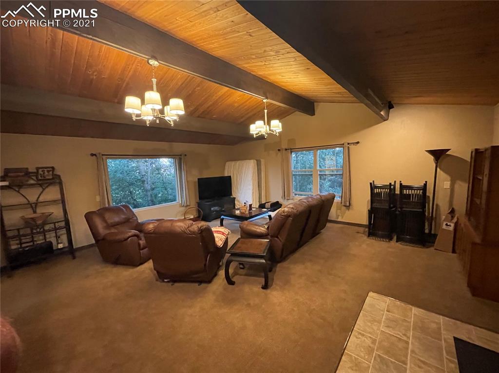 2160 Old North Gate Road Colorado Springs, CO 80921 - Photo 28 of 34 a living room with furniture a chandelier and a flat screen tv