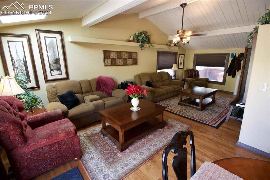 2160 Old North Gate Road Colorado Springs, CO 80921 - Photo 4 of 34 a living room with furniture a chandelier and a flat screen tv