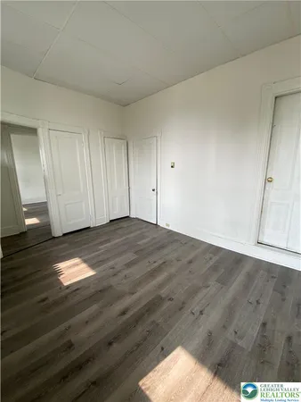 a view of empty room with wooden floor