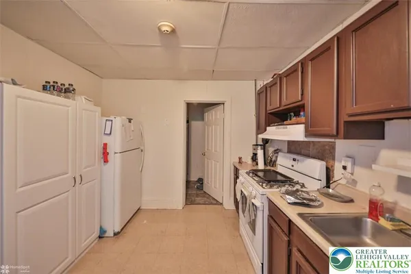 a kitchen with stainless steel appliances granite countertop a refrigerator a stove and a sink