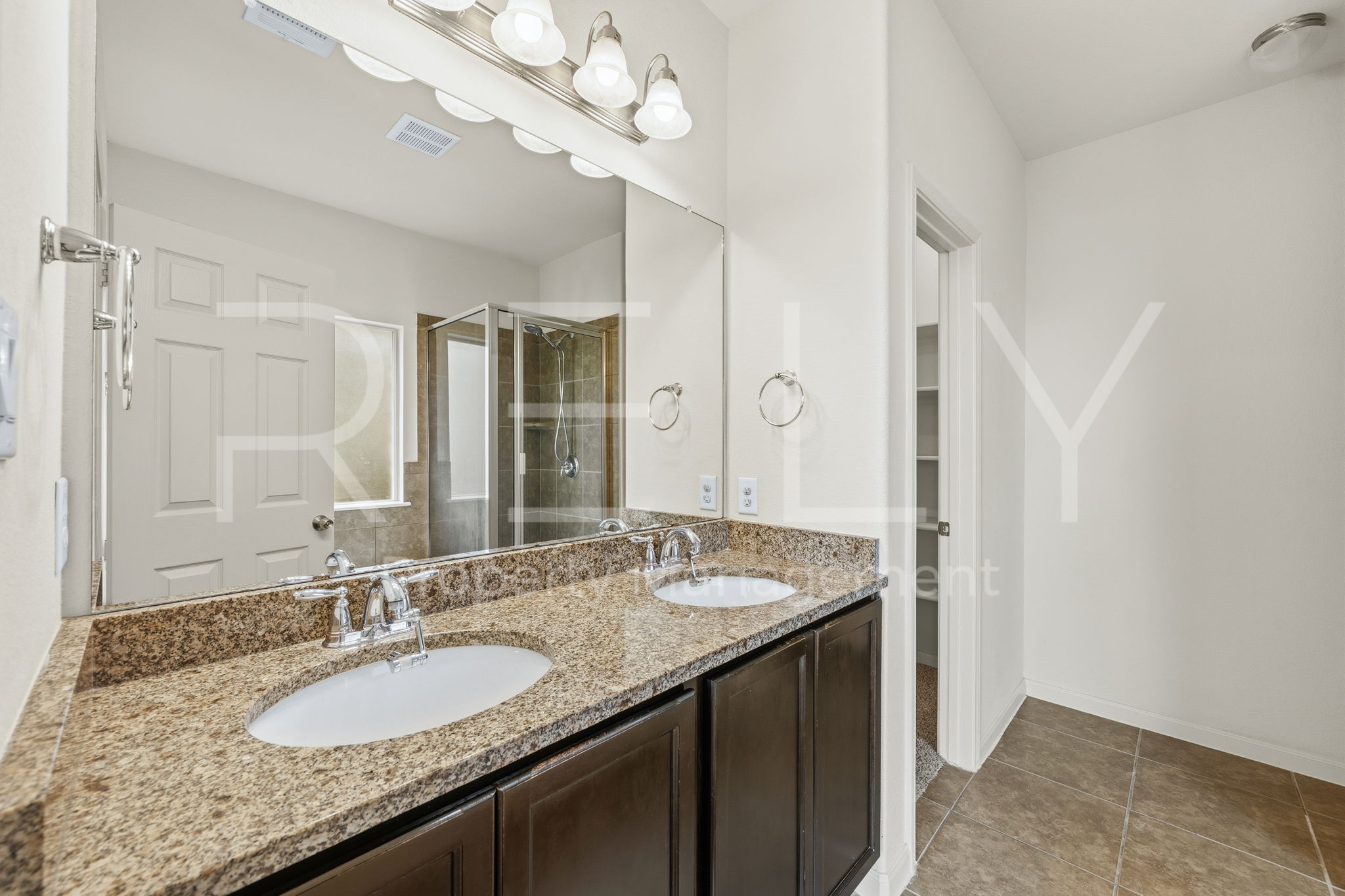 1405 Sunny Meadows Loop Georgetown, TX 78626 - Photo 19 of 40 Double vanity with stone countertops in a well-appointed primary bathroom.