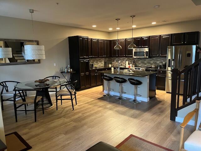 1527 Northwest 48th Lane Boca Raton, FL 33431 - Photo 6 of 23 a kitchen with stainless steel appliances kitchen island granite countertop a stove top oven a sink dishwasher a dining table and chairs with wooden floor