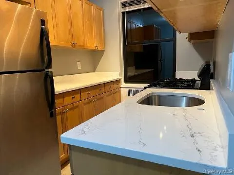 a kitchen with a sink a refrigerator and cabinets