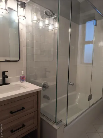 a bathroom with a sink a mirror and a shower