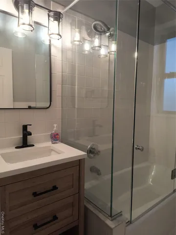 a bathroom with a sink a mirror and shower
