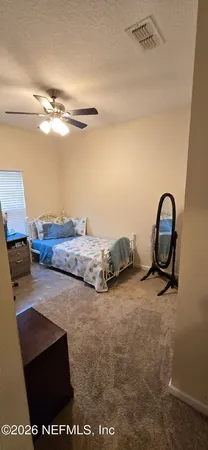 a view of a room with wooden floor and ceiling fan