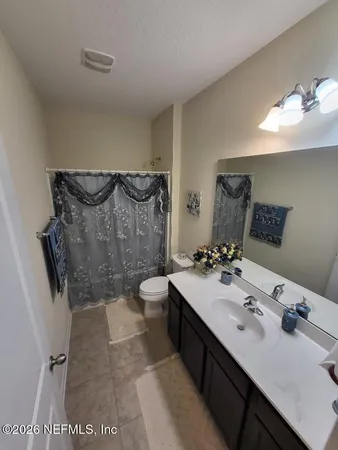 a bathroom with a double vanity sink mirror and toilet