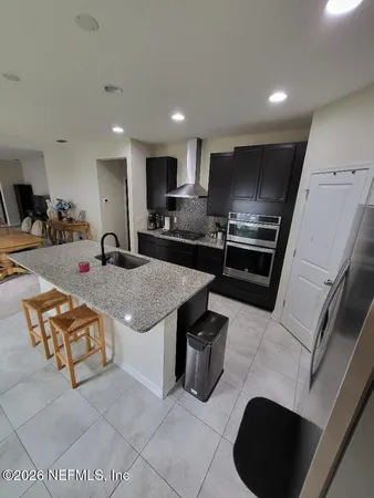 a kitchen with stainless steel appliances granite countertop a sink a stove and a refrigerator