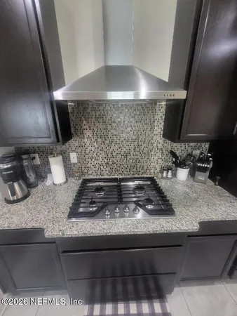 a kitchen with kitchen island granite countertop a sink a stove and a granite counter top