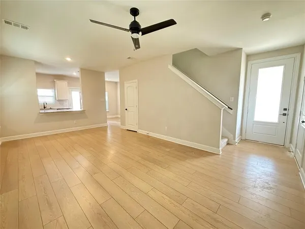 an empty room with wooden floor and windows