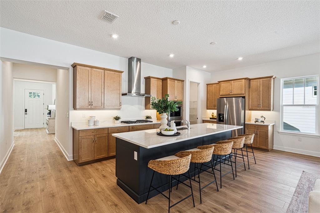 2006 Beach Terrace Celebration, FL 34747 - Photo 8 of 31 a kitchen with stainless steel appliances granite countertop a stove a refrigerator a sink dishwasher and a dining table with wooden floor