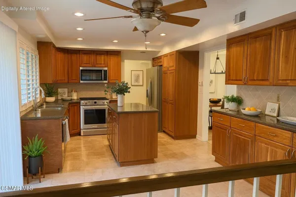 a kitchen with stainless steel appliances granite countertop a refrigerator a stove top oven a sink and dishwasher
