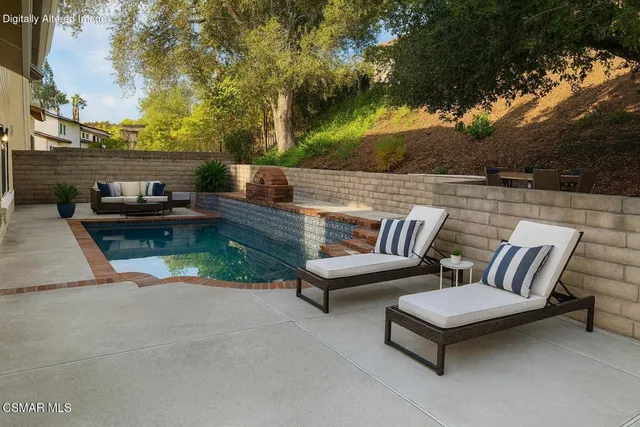 a backyard of a house with barbeque oven and outdoor seating