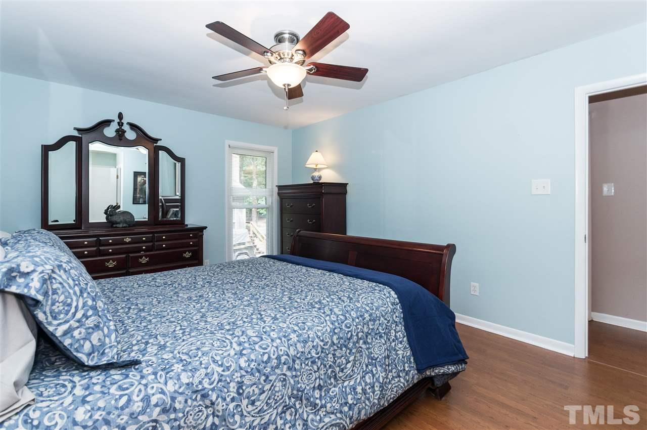 1421 Fairway Ridge Drive Raleigh, NC 27606 - Photo 11 of 19 a bedroom with a large bed and a chandelier