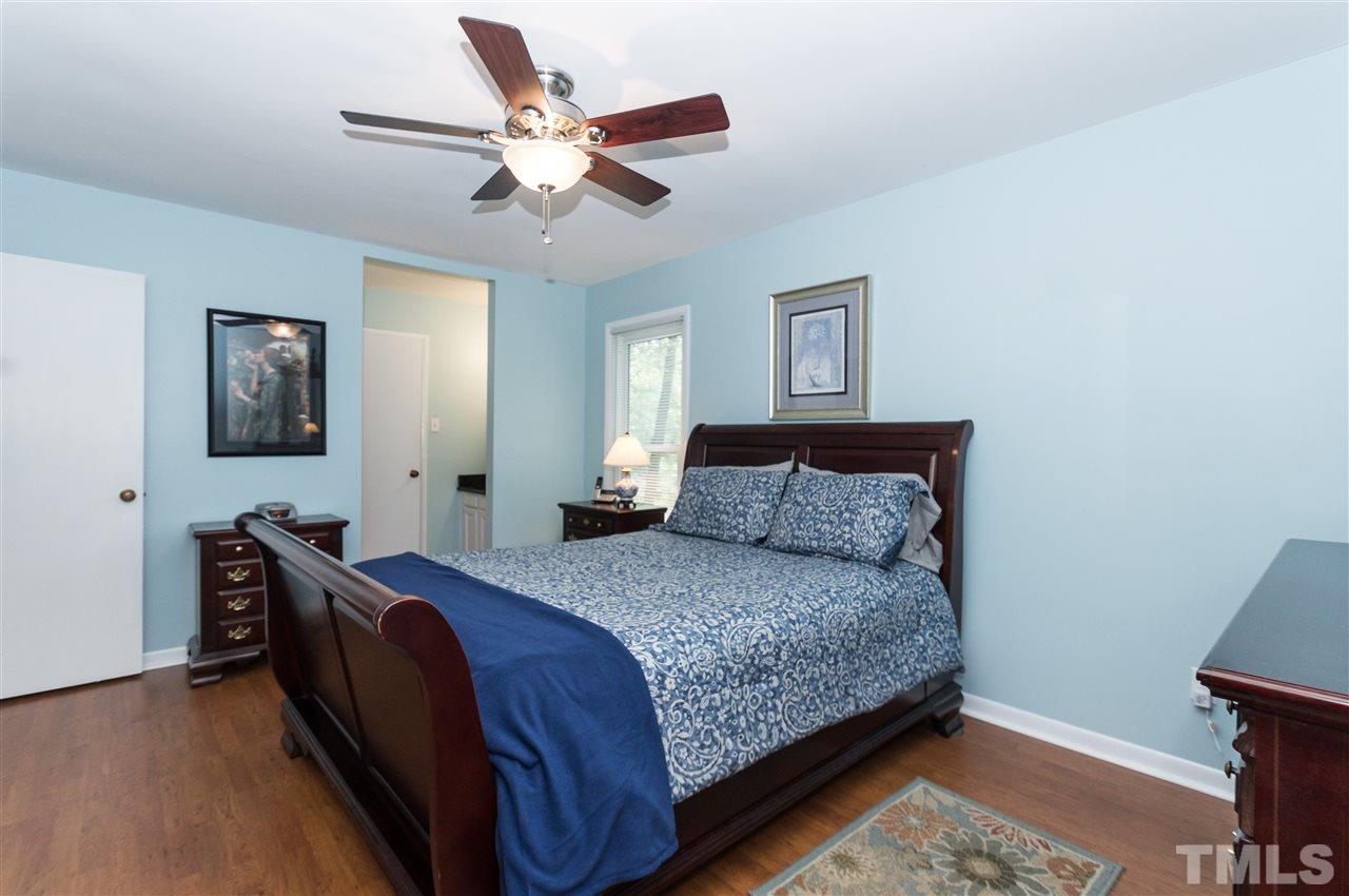 1421 Fairway Ridge Drive Raleigh, NC 27606 - Photo 12 of 19 a bedroom with a bed and a chandelier