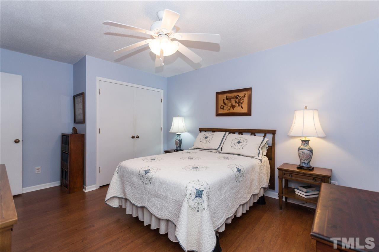 1421 Fairway Ridge Drive Raleigh, NC 27606 - Photo 14 of 19 a large bedroom with a bed and a chandelier