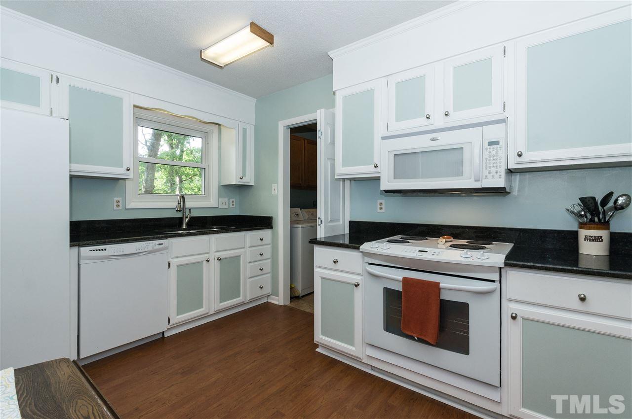 1421 Fairway Ridge Drive Raleigh, NC 27606 - Photo 7 of 19 a kitchen with stainless steel appliances white cabinets granite counter tops and a window