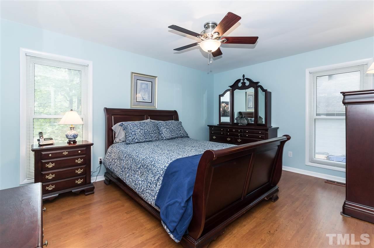 1421 Fairway Ridge Drive Raleigh, NC 27606 - Photo 10 of 19 a spacious bedroom with a bed and a chandelier