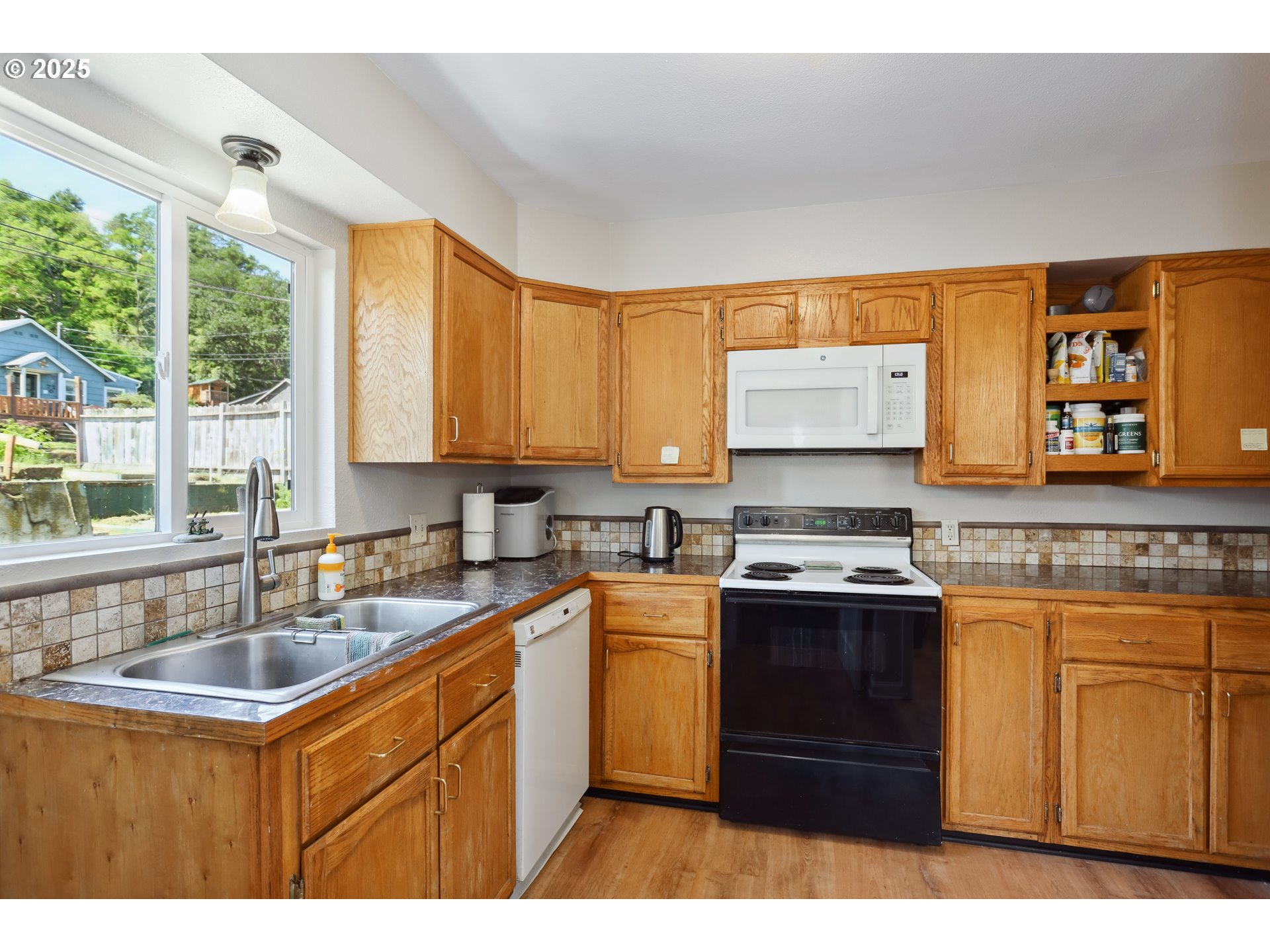 722 East 14th Street The Dalles, OR 97058 - Photo 11 of 43 a kitchen with stainless steel appliances granite countertop a sink stove and refrigerator