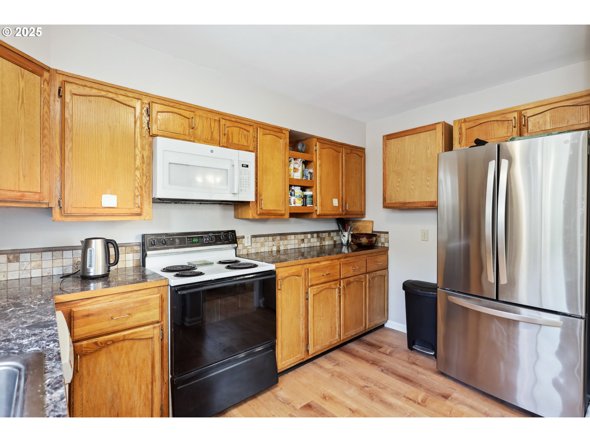 722 East 14th Street The Dalles, OR 97058 - Photo 10 of 43 a kitchen with stainless steel appliances a refrigerator sink and cabinets