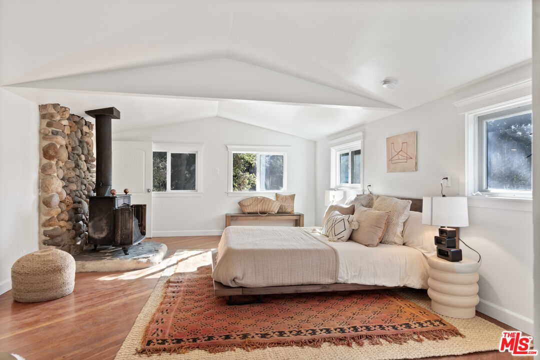 20939 Hillside Drive Topanga, CA 90290 - Photo 27 of 53 a bedroom with a bed and wooden floor