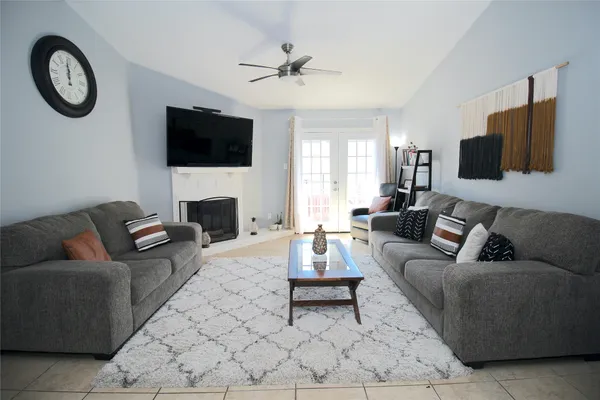 a living room with furniture a flat screen tv and a fireplace