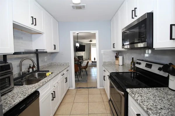 a kitchen with stainless steel appliances granite countertop a sink stove and cabinets