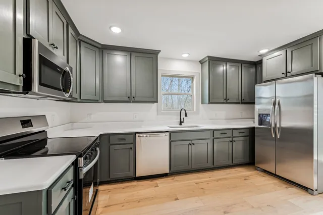 a kitchen with stainless steel appliances granite countertop a sink stove and refrigerator