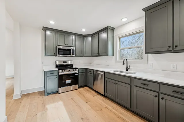 a kitchen with stainless steel appliances granite countertop a sink and stove top oven