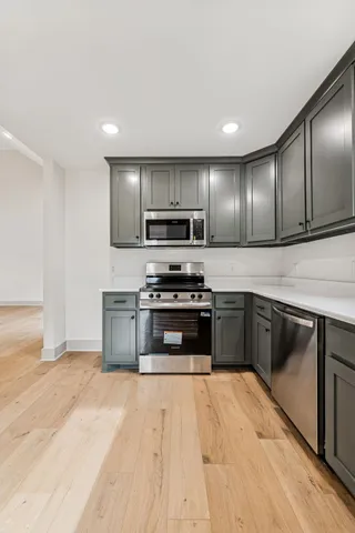 a kitchen with stainless steel appliances kitchen island granite countertop a stove a sink and a microwave