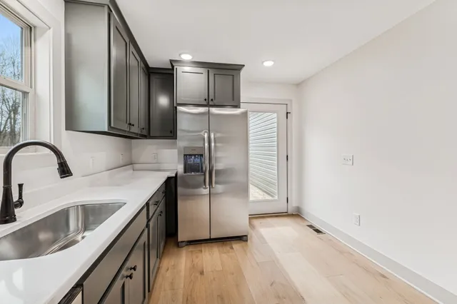 a kitchen with stainless steel appliances granite countertop a refrigerator a sink a stove and island