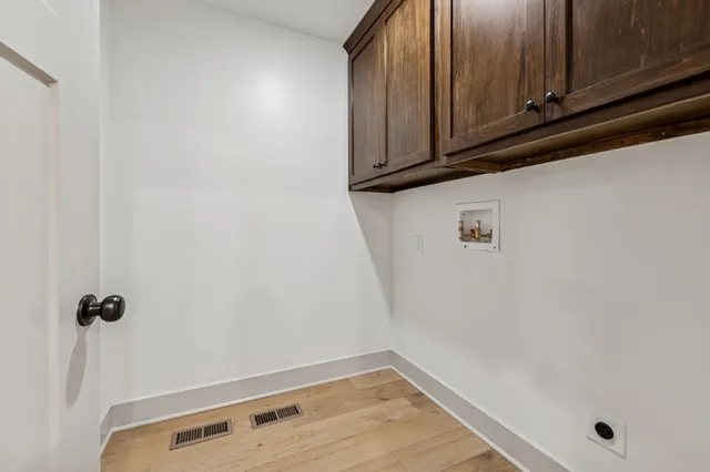 a view of a storage and utility room with wooden floor